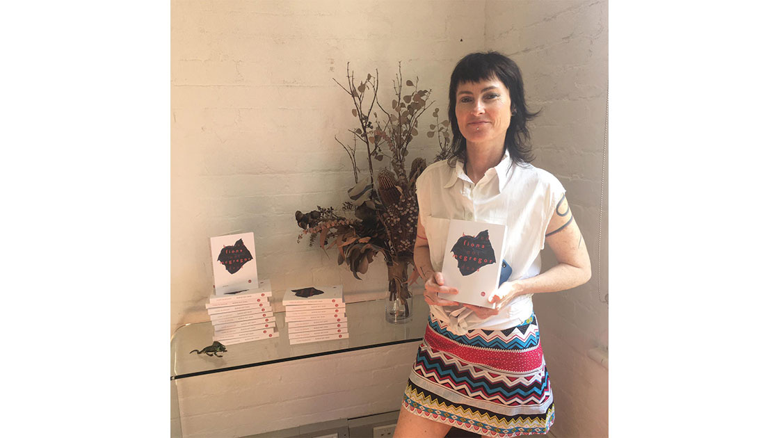 Fiona McGregor pictured with copies of Buried Not Dead, courtesy Giramondo